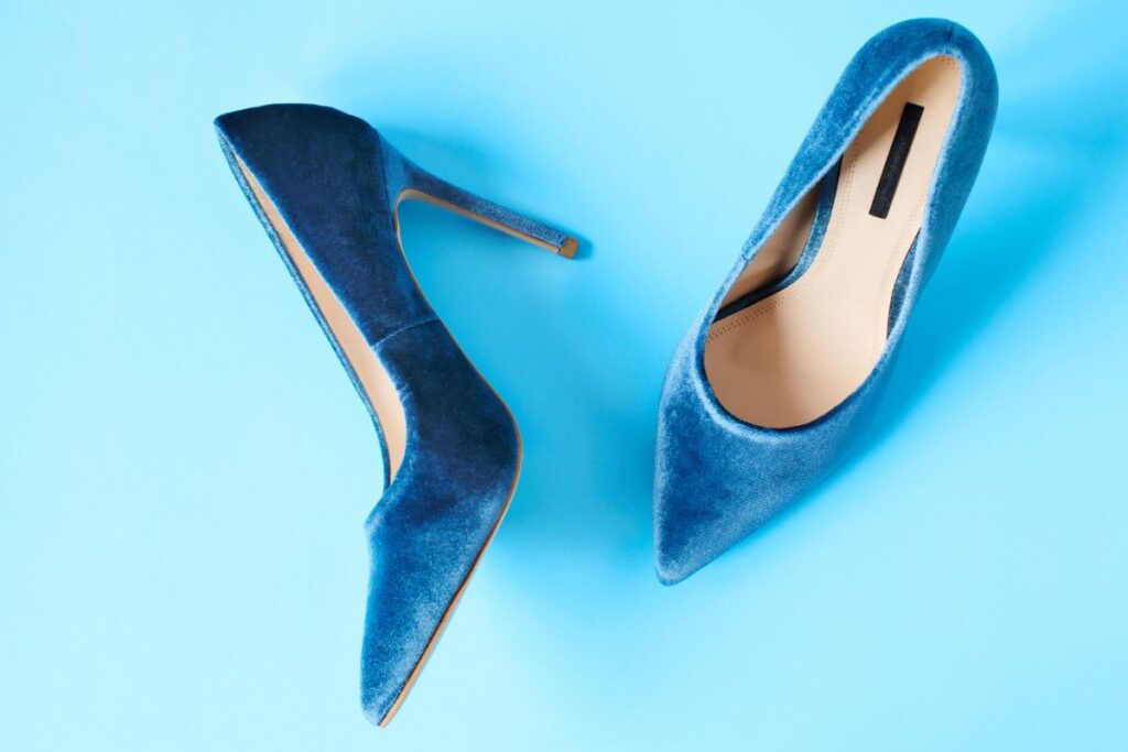 A striking blue velvet pump with a classic pointed-toe silhouette and a slender stiletto heel