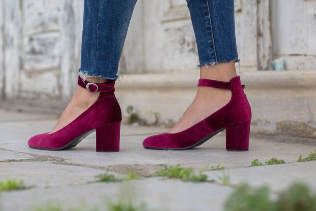 A stylish burgundy velvet block-heel pumps with a rounded toe and an ankle strap