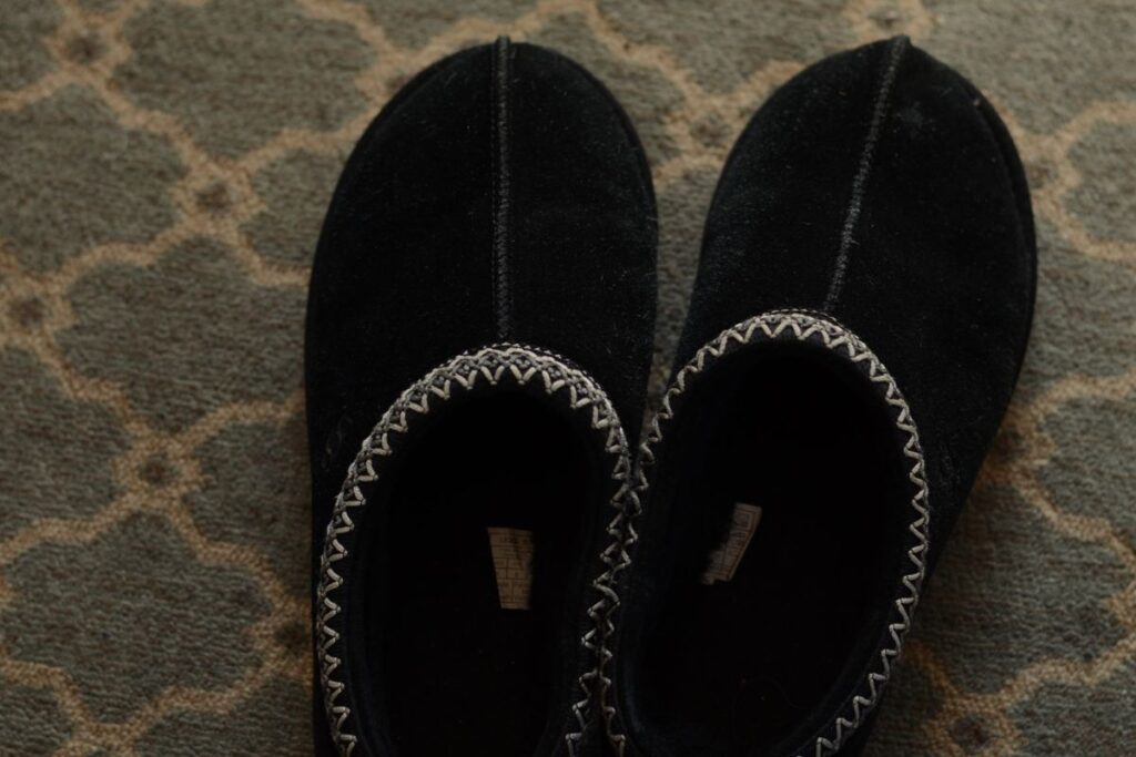 A pair of black UGG Tasman Slippers