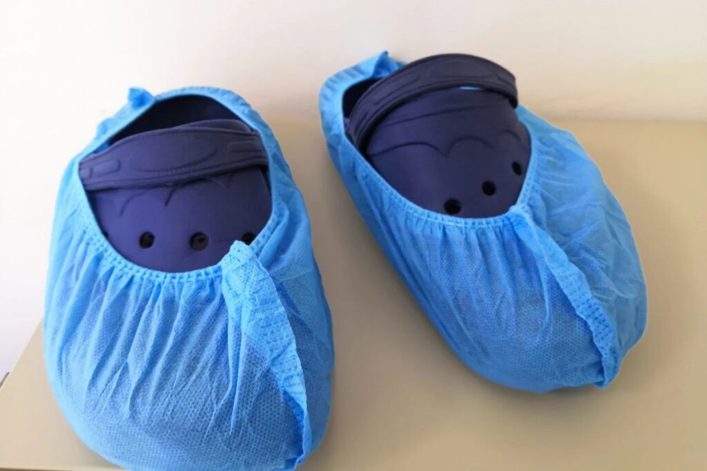 Crocs covered with disposable shoe covers